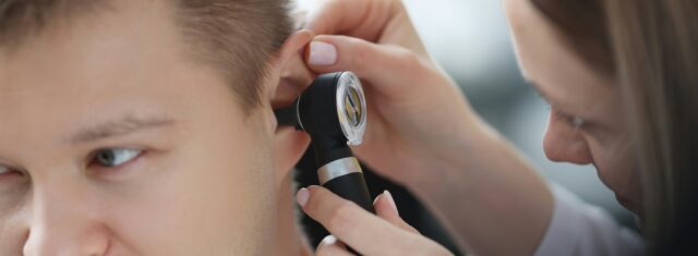 Man getting his ear checked by audiologist