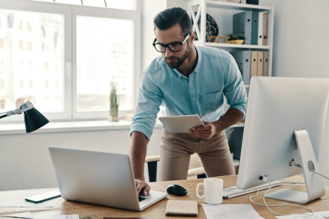 Man working on multiple screens
